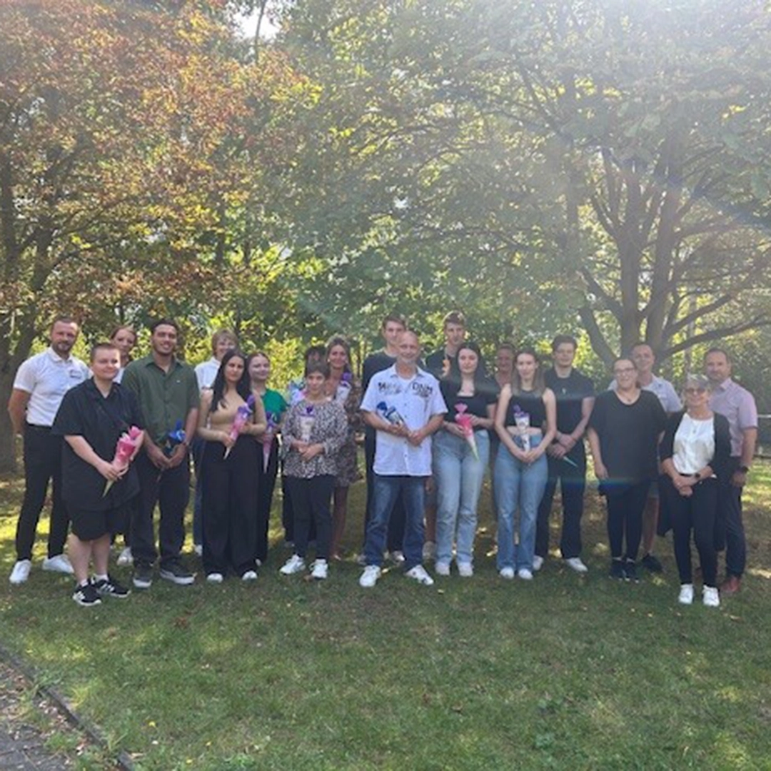Gruppenbild zum Ausbildungsstart 2025 bei der HBG Gera mit neuen Auszubildenden und Teammitgliedern im Gartenbereich