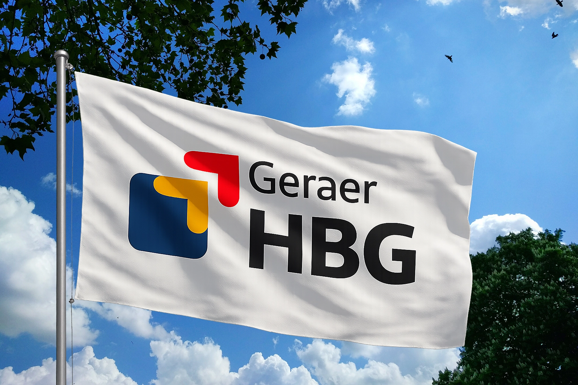 Fahne mit HBG-Logo der Geraer Heimbetriebsgesellschaft weht vor blauem Himmel – Symbol für Identität und Außendarstellung.