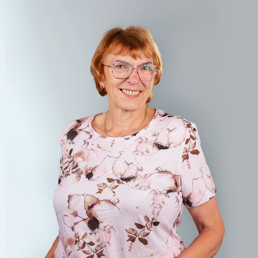 Porträt von Frau Bogdanowa, Ansprechpartnerin der Geraer Heimbetriebsgesellschaft, vor grauem Hintergrund – sie lächelt freundlich in die Kamera.