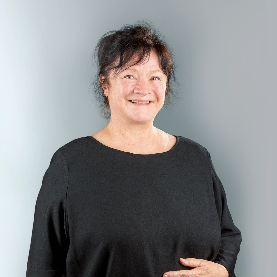 Porträt von Frau Gruner, Ansprechpartnerin der Geraer Heimbetriebsgesellschaft, vor grauem Hintergrund – sie blickt freundlich in die Kamera.