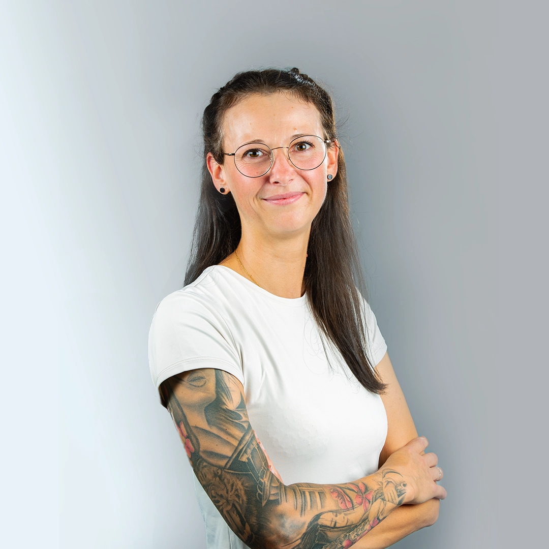 Junge Frau mit Brille, weißem Shirt und tätowiertem Arm – Ansprechpartnerin der Geraer HBG.
