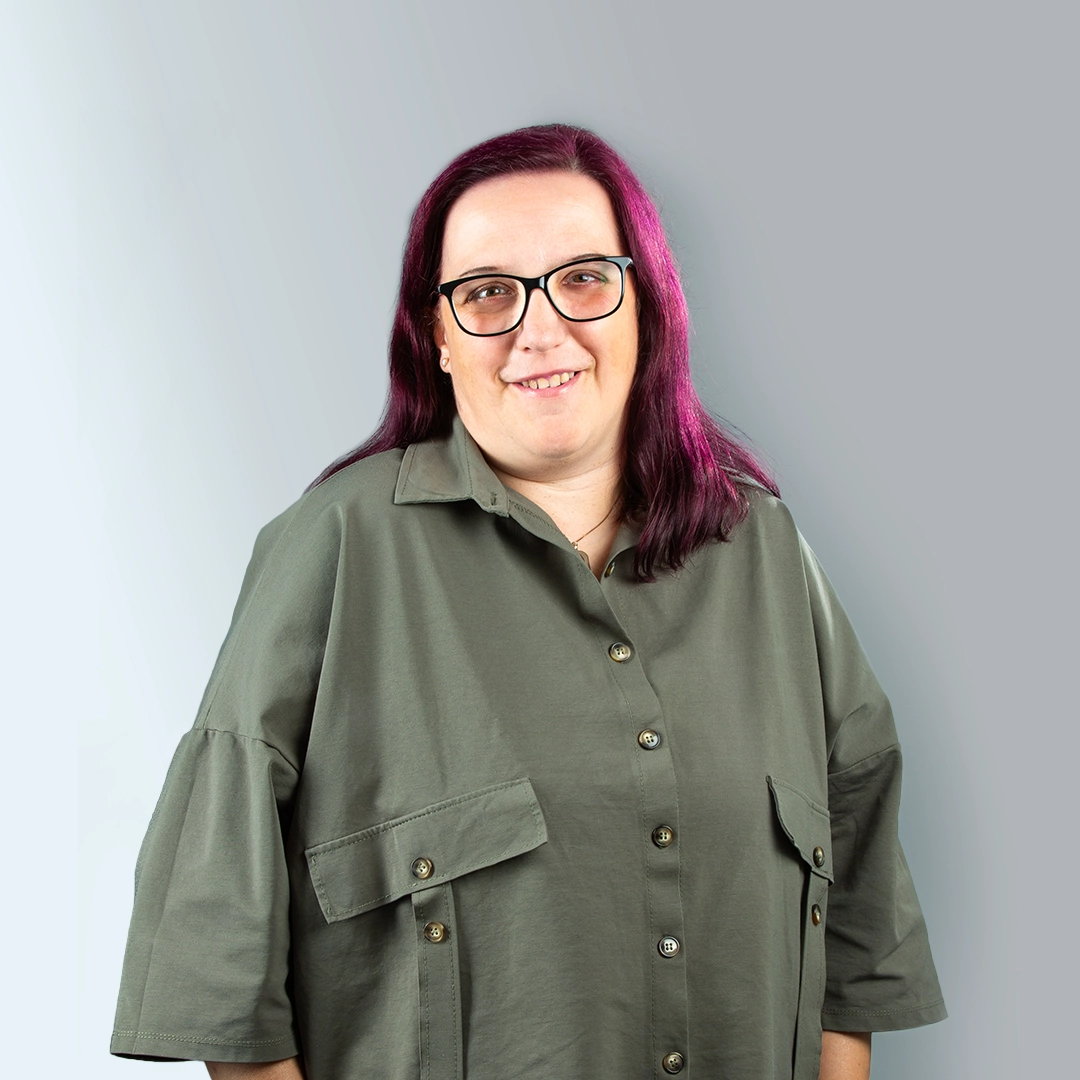 Porträt von Frau Schade, Mitarbeiterin der Geraer Heimbetriebsgesellschaft mbH mit violetten Haaren und Brille