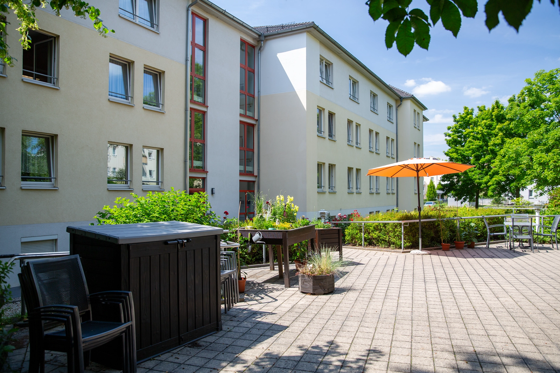 Außenansicht des Seniorenpflegeheims mit Garten und Parkplätzen.