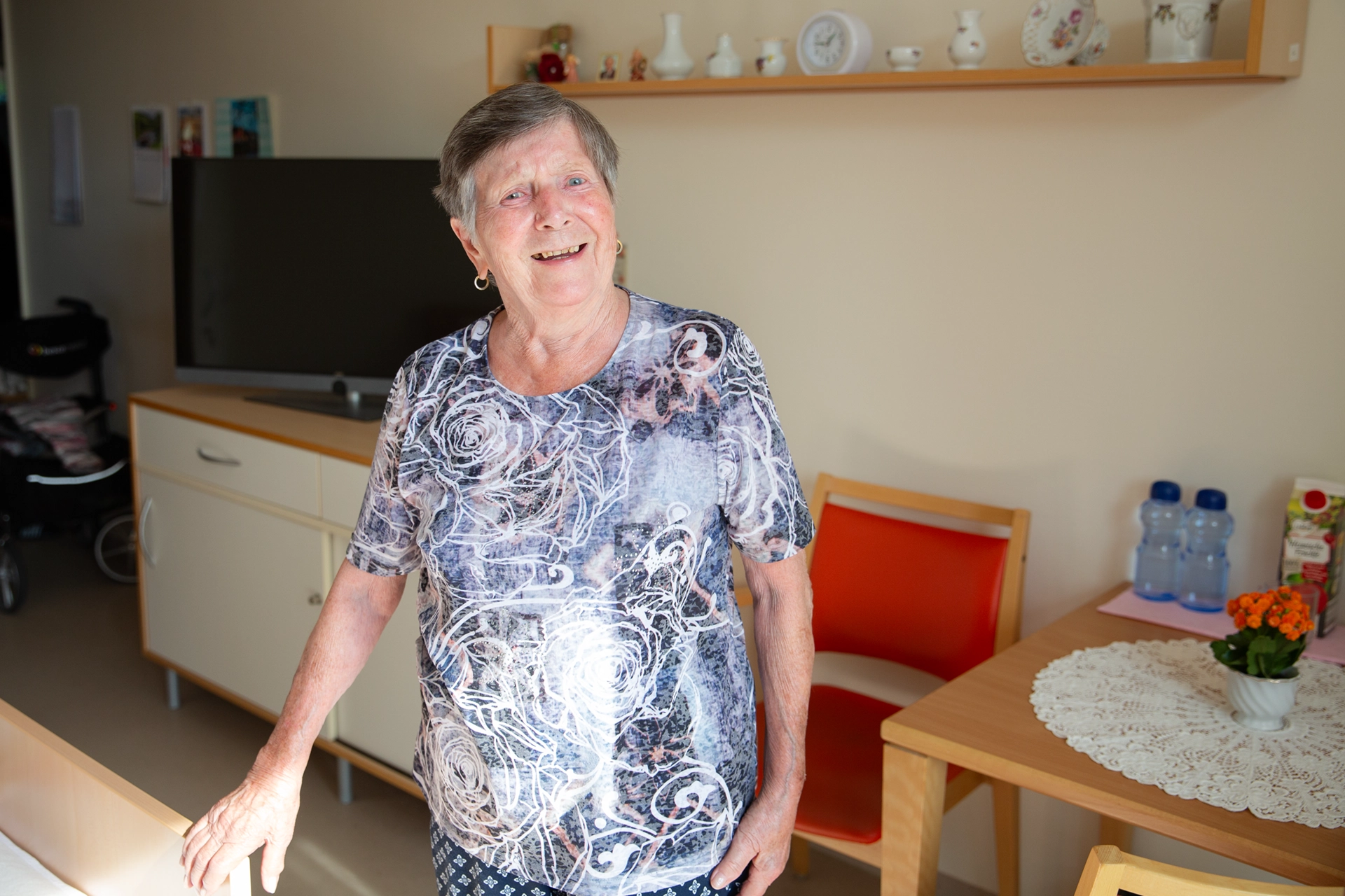 Seniorin steht lächelnd in ihrem persönlich gestalteten Zimmer im Pflegeheim Otto Dix der HBG Gera